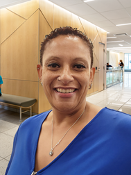 A smiling woman standing in the hallway