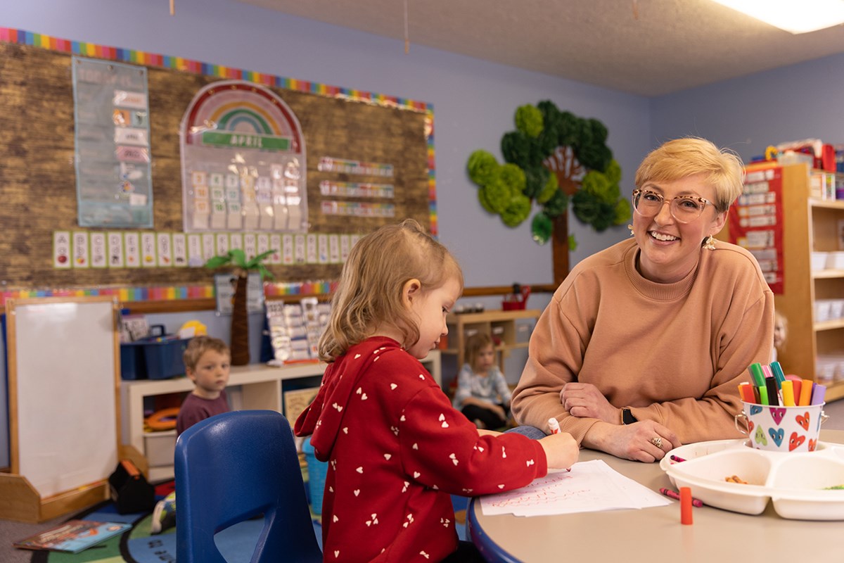 Teacher smiling with child in classroom